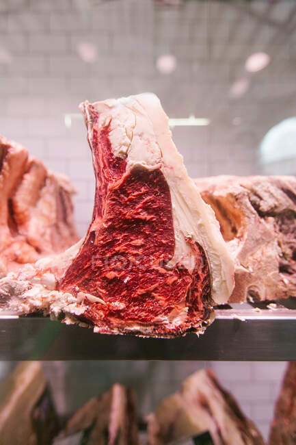 Filete de ternera crudo en un refrigerador en una carnicería para madurar - foto de stock