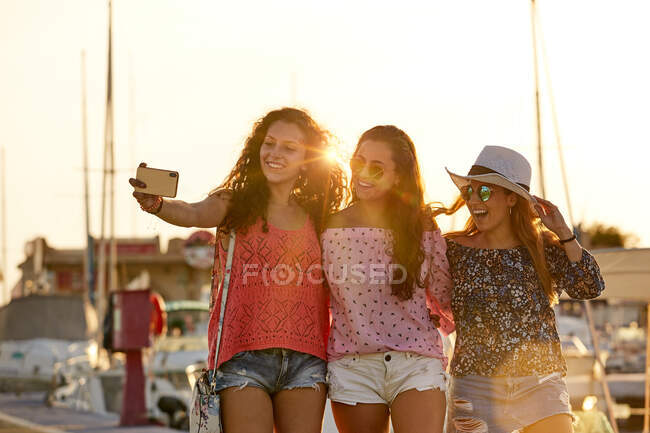 Compañeros optimistas que se unen y disparan selfie en verano - foto de stock