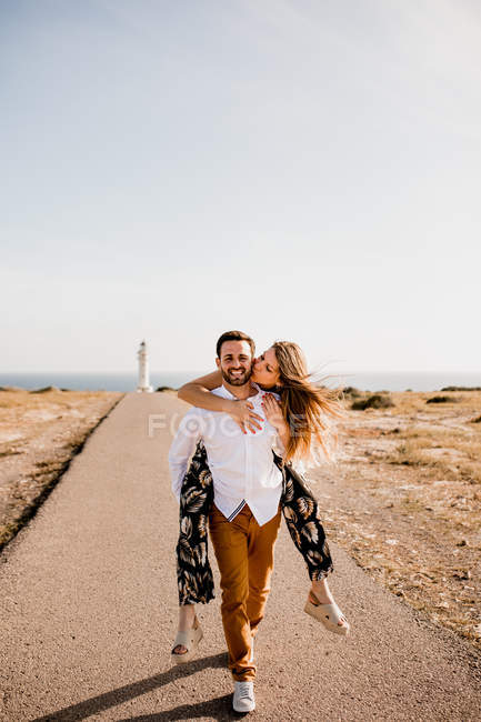 Happy lovers having fun on path from sea — Stock Photo