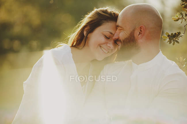 Casal concurso abraçando enquanto está em pé no campo rural — Fotografia de Stock