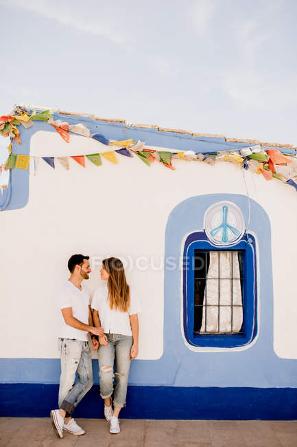 Zartes Paar stützt sich im Sommer auf festlich-authentisches Gebäude und schaut sich an — Stockfoto