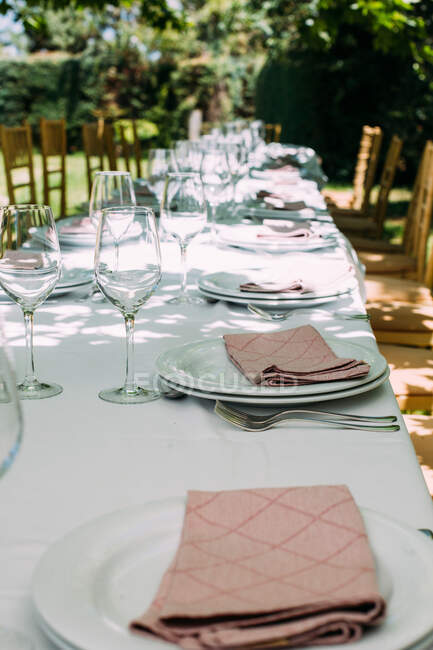 Outdoor rustic celebration table with cutlery and glasses — Stock Photo