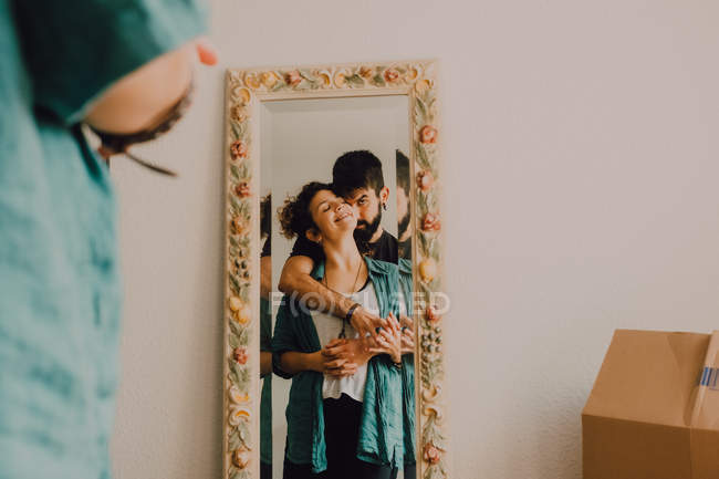Reflet d'un couple tendre embrassant dans un grand miroir décoré — Photo de stock