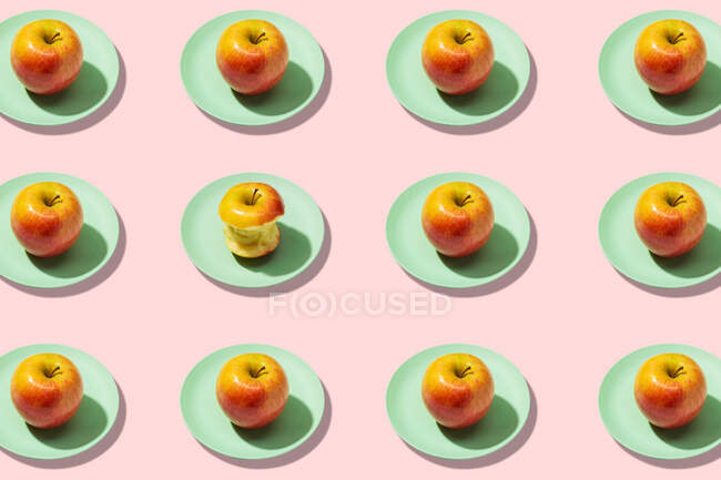 Frische Äpfel im Teller auf rosa Hintergrund. Lebendiges buntes Muster — Stockfoto