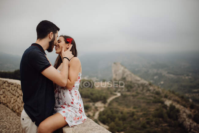 Sensual couple kissing while resting on rural observation desk — Stock Photo