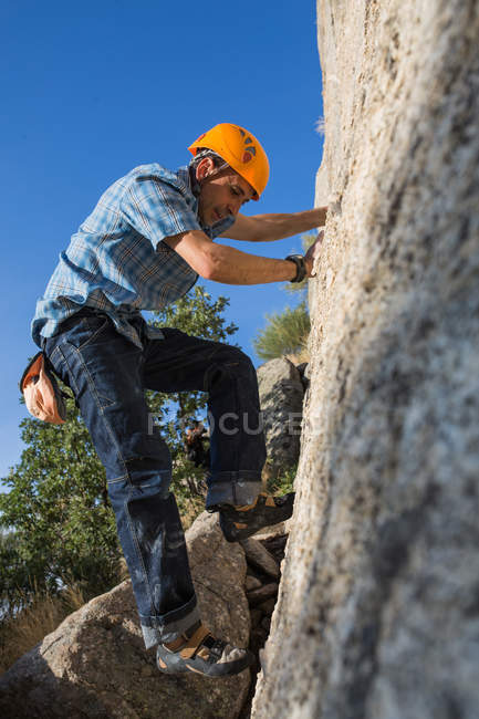 Desde abajo de escalador libre escalando en la naturaleza - foto de stock