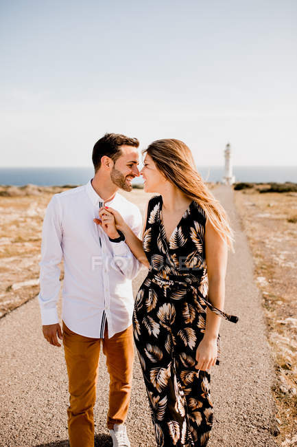 Happy lovers walking on path from sea — Stock Photo