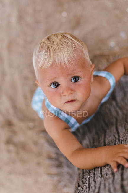 Vista superior de un bebé rubio en la playa - foto de stock