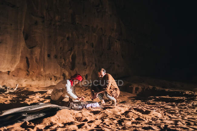 Arabische Männer graben Sand in der Nähe von Klippen — Stockfoto