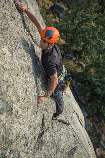 Von oben besteigt der Mensch mit Kletterausrüstung einen Felsen in der Natur — Stockfoto