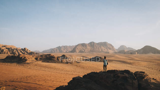 Woman stands on top of the rock looking at Wadi Rum — Stock Photo