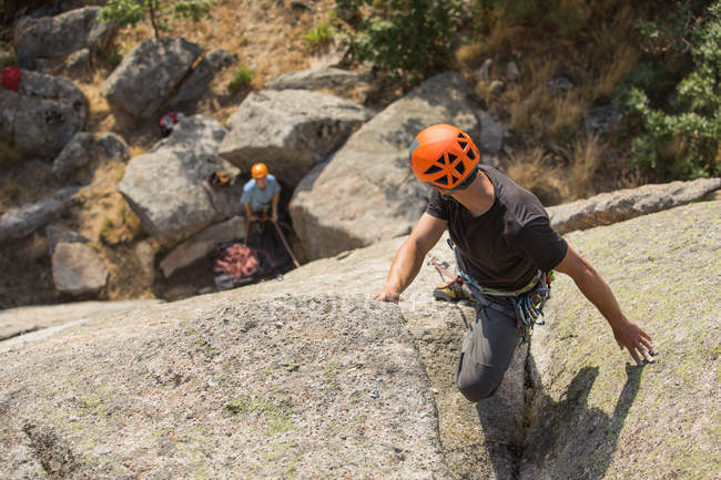 Авантюристы, взбирающиеся на гору, надевающие ремни безопасности на живописный ландшафт — стоковое фото