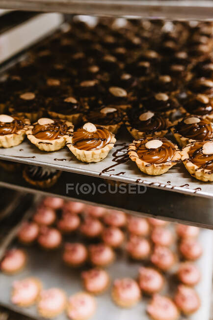 Conjunto de close-up de massa gostosa com creme de caramelo doce e nozes dispostas em pergaminho — Fotografia de Stock