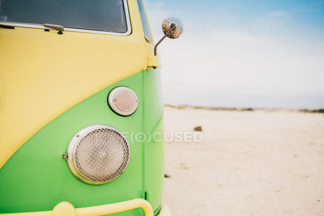 Bright retro minibus with round headlights on beach — Stock Photo