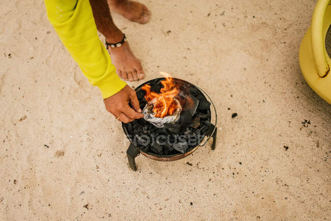 Загорелый мужчина готовит на печи рядом с припаркованным минивэном — стоковое фото