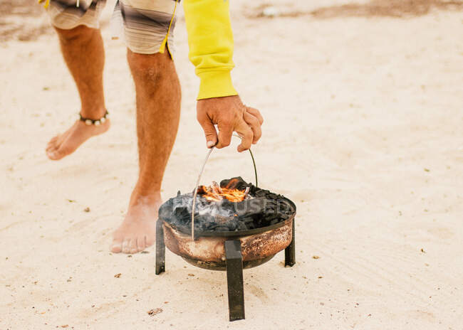Tanned man cooking on camping stove beside parked mini van — Stock Photo