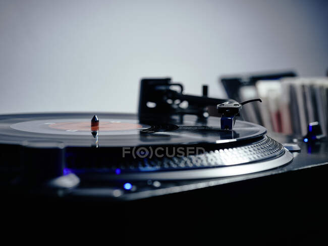 Closeup of top of old black turntable with tonearm maintaining position of cartridge tracing groove and playing LP record — Stock Photo