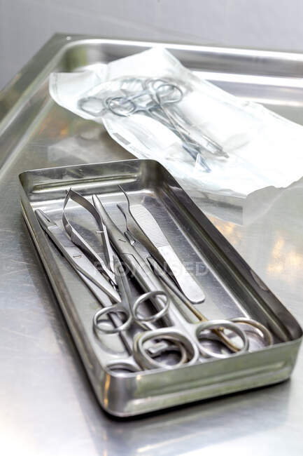 З - над сталевого лотка з стерильними хірургічними ножицями і щипцями на металевому столі в клініці. — стокове фото