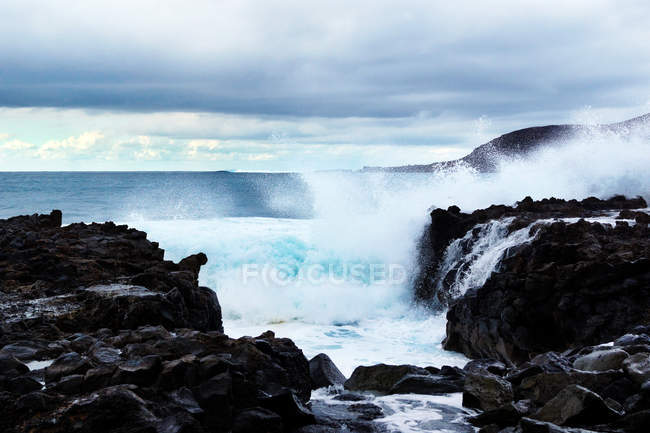 Ondas azuis de oceano com textura de espuma branca contra rochas — Fotografia de Stock