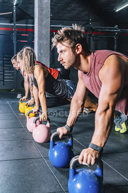 Вид збоку на спортсменів, які тренуються з вагою в тренажерному залі — стокове фото