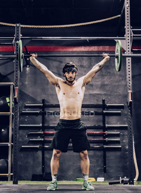 Homem forte e atlético fazendo treino de barbell no ginásio moderno — Fotografia de Stock
