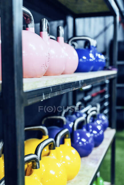 Conjunto de kettlebells coloridos nas prateleiras no moderno health club — Fotografia de Stock