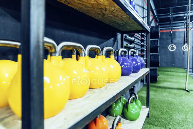 Set bunter Wasserkocher in den Regalen des modernen Fitnessclubs — Stockfoto