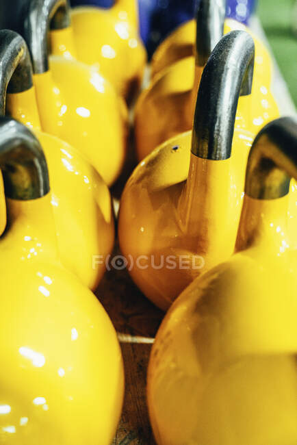 Conjunto de kettlebells amarelos nas prateleiras do moderno health club — Fotografia de Stock