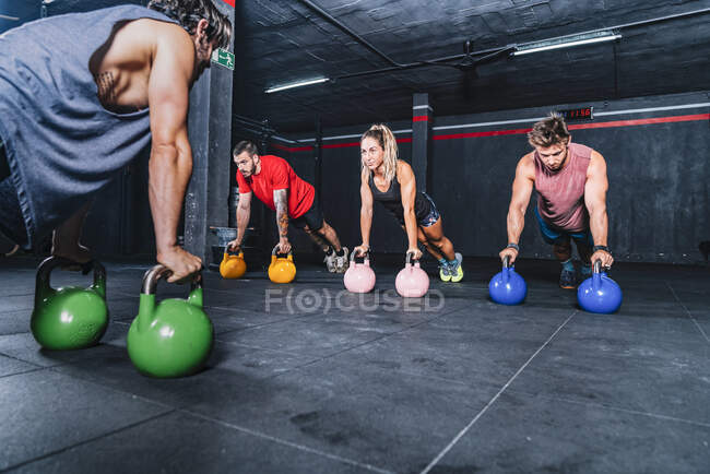 Companheiros fortes atléticos fazendo treino com peso no ginásio — Fotografia de Stock