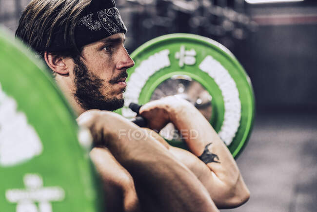 Starker und athletischer Mann beim Langhanteltraining in modernem Fitnessstudio — Stockfoto
