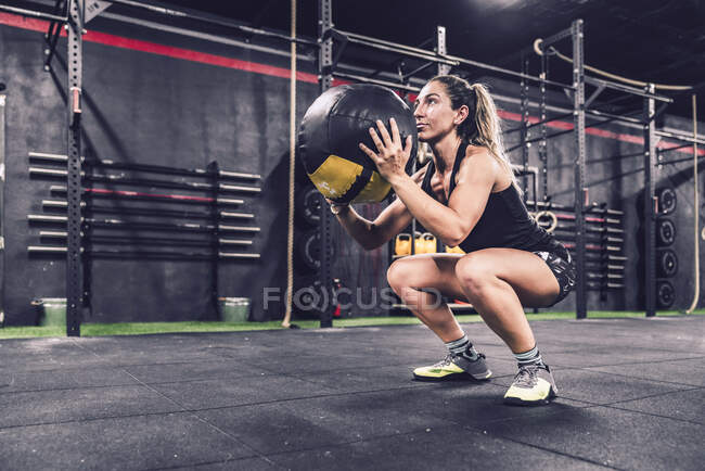 Athletische Frau im Sportbekleidungstraining mit Fitball im Fitnessstudio — Stockfoto