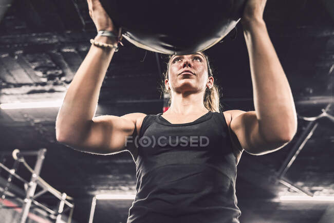 Von unten athletische Frau im Sportbekleidungstraining mit Fitball im Fitnessstudio — Stockfoto