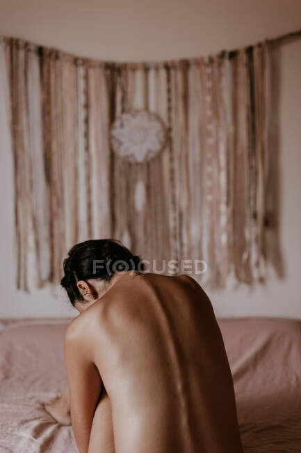 Mulher nua sentada na cama — Fotografia de Stock