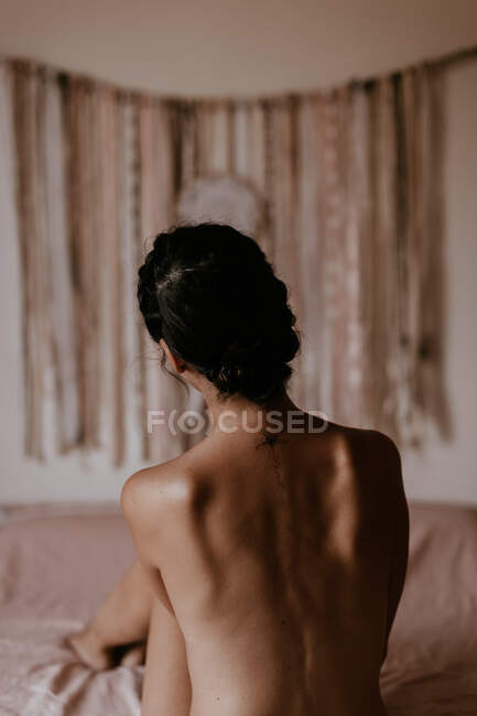 Голая женщина сидит на кровати — стоковое фото