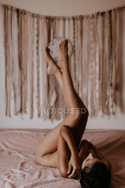 Mujer desnuda acostada en la cama - foto de stock