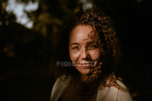 Donna sorridente in piedi nella foresta — Foto stock