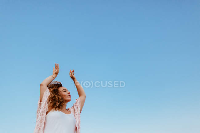 Mulher feliz levantando braços para o céu — Fotografia de Stock