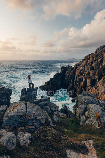 Femme regardant les rochers au bord de la mer — Photo de stock