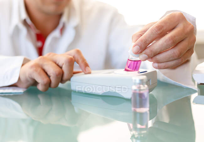 Vial macho de cultivo con muestra química en dispositivo médico electrónico para realizar investigaciones en laboratorio - foto de stock