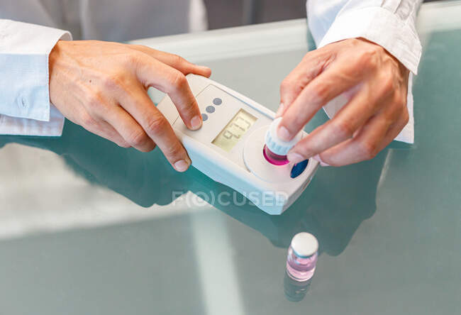 Assistente trabalhando em laboratório com líquido rosa — Fotografia de Stock