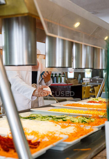 Adult employee checking food quality in canteen — Stock Photo