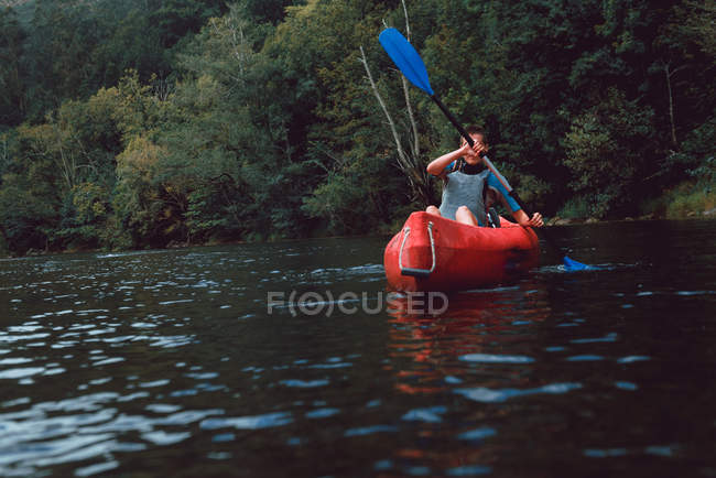 Sportive жінка, що сидить у червоному каное і веслування на Селла спад в Іспанії — стокове фото