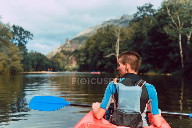 Вид сзади на атлетку в красном каноэ на реке Селла в Испании — стоковое фото