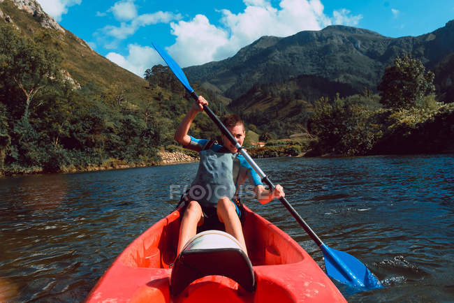 Спортивний жіночий canoeist сидячи в червоному каное і веслування на Селла спад в Іспанії — стокове фото