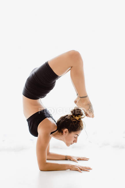 Adatta donna che esegue posa yoga in studio — Foto stock
