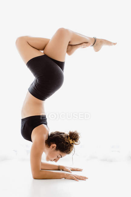 Підійде жінка, що виконує позу йоги на білому тлі — стокове фото