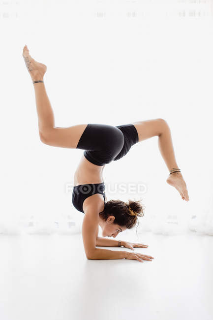 Спортивная женщина, исполняющая позу йоги в студии — стоковое фото