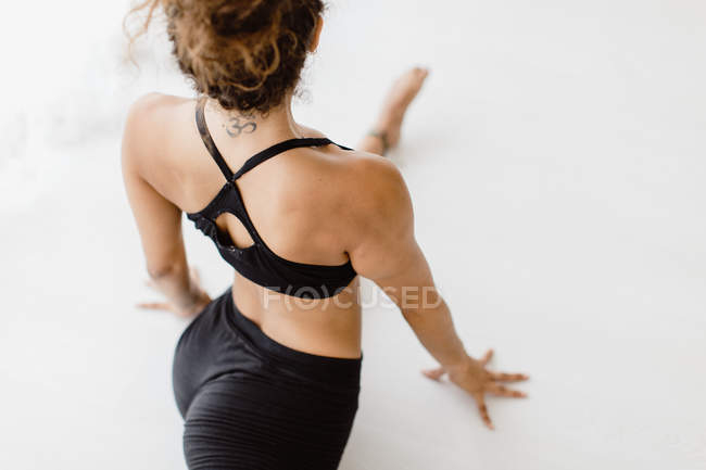 Спортивна жінка, що виконує йогу позу в студії, високий кут зору — стокове фото