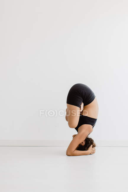 Подходящая женщина, исполняющая позу йоги на белом фоне — стоковое фото