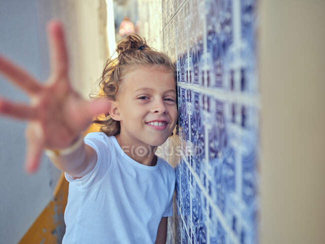 Focus selettivo di contenuti bambino appoggiato al muro in Portogallo e guardando la fotocamera — Foto stock